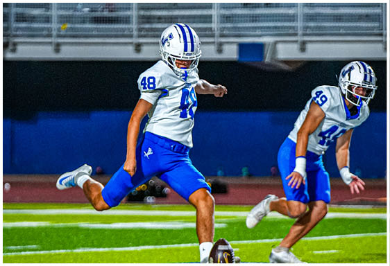 A football player wearing a blue and white uniform. Description generated by AI