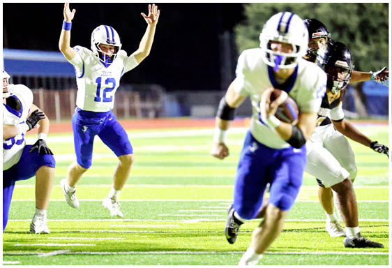 A football player wearing a blue and white uniform. Description generated by AI