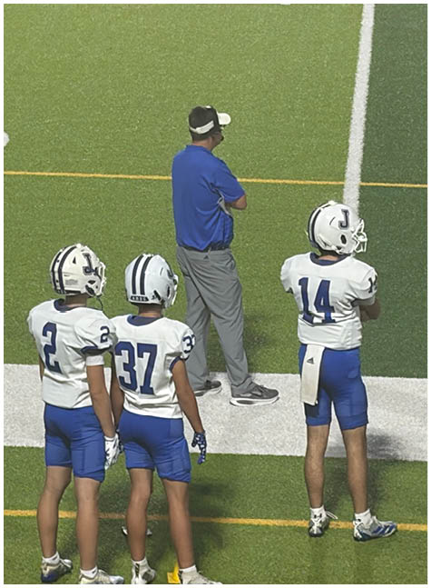 A group of football players on a field. Description generated by AI