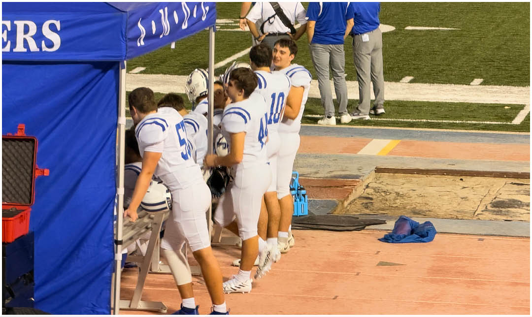 A football player wearing a blue and white uniform. Description generated by AI