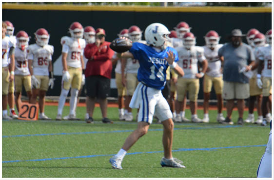 Three football players in blue and white uniforms running on a field. Description generated by AI