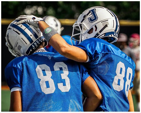 A group of football players on a field. Description generated by AI