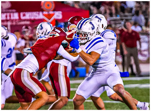 A football player wearing a blue and white uniform. Description generated by AI