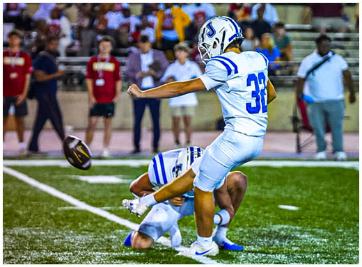 A football player wearing a blue and white uniform. Description generated by AI