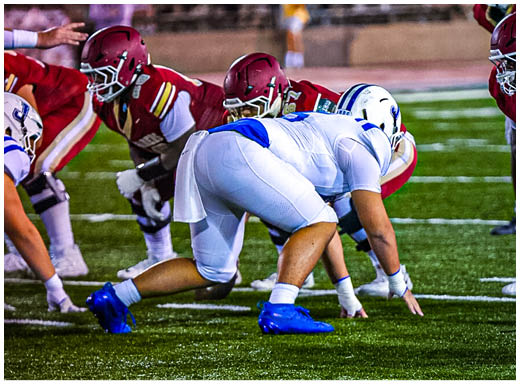 A football player wearing a blue and white uniform. Description generated by AI