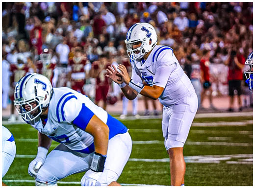 A football player wearing a blue and white uniform. Description generated by AI
