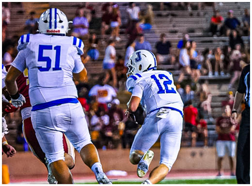 A football player wearing a blue and white uniform. Description generated by AI