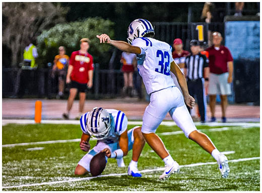 A football player wearing a blue and white uniform. Description generated by AI