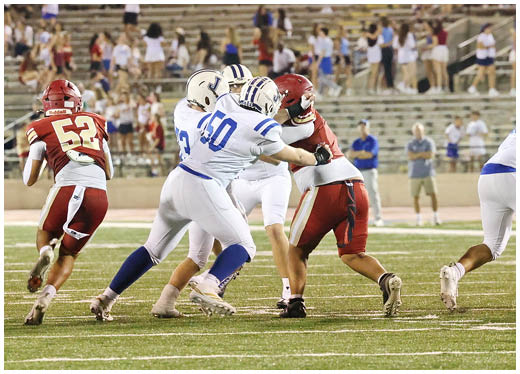 Three football players in blue and white uniforms running on a field. Description generated by AI
