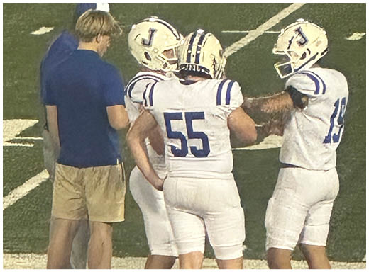 A football player wearing a blue and white uniform. Description generated by AI