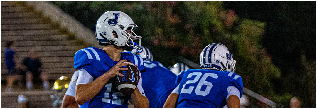A football player wearing a blue and white uniform. Description generated by AI