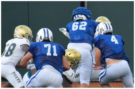 A group of football players on a field. Description generated by AI
