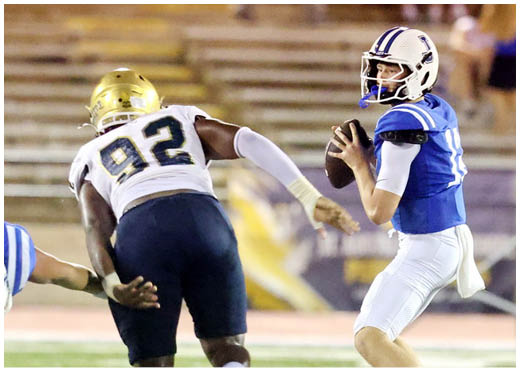 A football player wearing a blue and white uniform. Description generated by AI