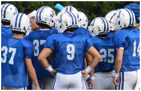 A group of football players on a field. Description generated by AI