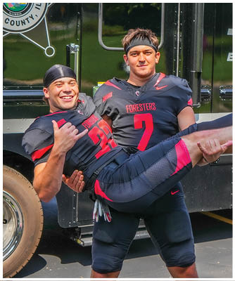 A man wearing a football jersey is being carried by another man. Description generated by AI
