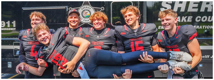 A group of football players posing for a picture. Description generated by AI