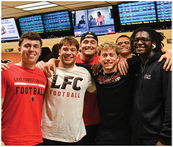 A group of men wearing red and black shirts. Description generated by AI
