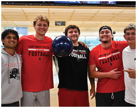 A group of men wearing red and black shirts. Description generated by AI