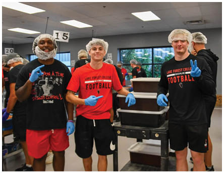 A group of people wearing hairnets and gloves. Description generated by AI