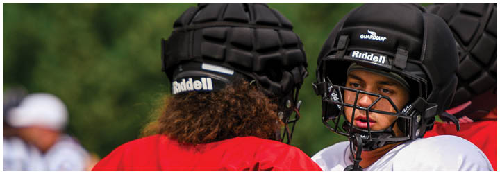 Two football players wearing red and black uniforms. Description generated by AI