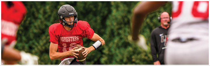 A football player in a red jersey with the number 11 on it. Description generated by AI