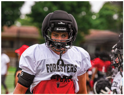 A football player wearing a black helmet and red jersey. Description generated by AI