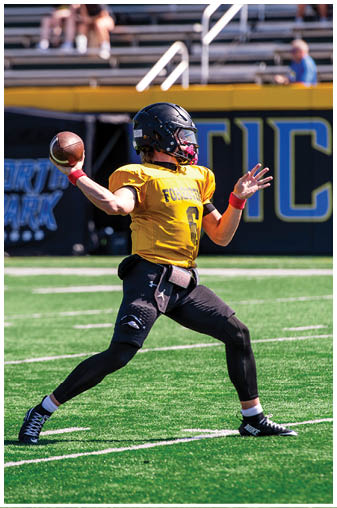 A football player wearing a yellow jersey and red wristbands. Description generated by AI