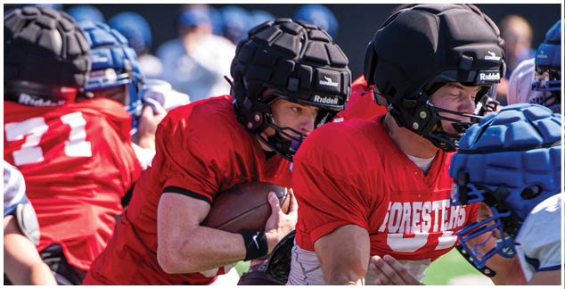 A football player in a red jersey with the number 27 on it. Description generated by AI