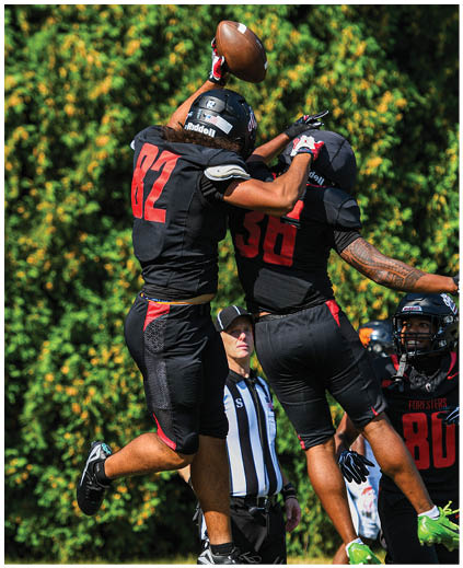 A football player is jumping in the air to catch a football. Description generated by AI