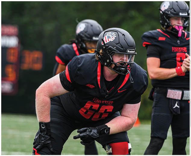 A football player wearing a black jersey with the number 66. Description generated by AI