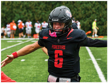 A football player wearing a black jersey with the number 5 on it. Description generated by AI