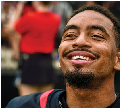 A man wearing a black jersey with the word “Minnesota" on it. Description generated by AI
