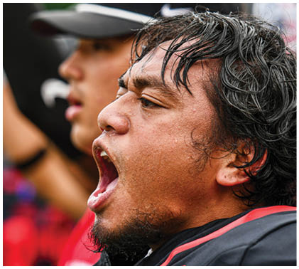A man wearing a football jersey with the number 12 on it. Description generated by AI