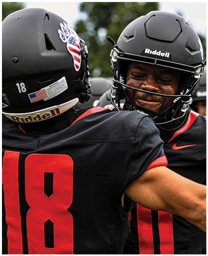 A football player wearing a helmet and a red jersey. Description generated by AI