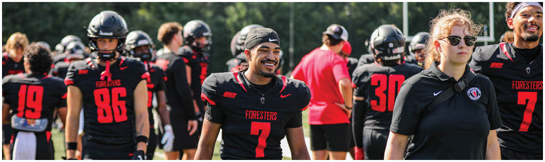 A group of people wearing black and red uniforms. Description generated by AI