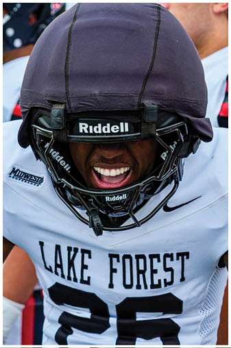 A football player wearing a helmet with the number 26 on it. Description generated by AI