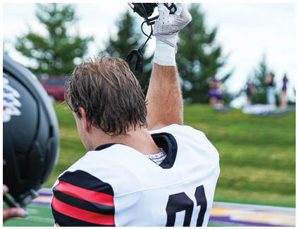 A man wearing a football helmet with the number 80 on it. Description generated by AI