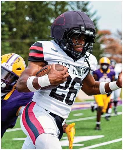 A football player running with a ball. Description generated by AI