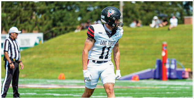 A football player wearing a white jersey with the number 11 on it. Description generated by AI
