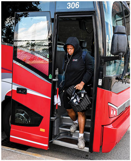 A man is standing in the doorway of a bus. Description generated by AI