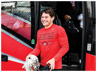 A man holding a football helmet and football gloves. Description generated by AI