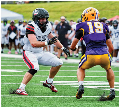 Two football players on a field. Description generated by AI