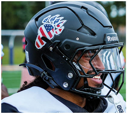A football player wearing a helmet with the number 7 on it. Description generated by AI