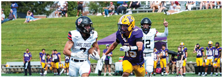 Two football players running on a field. Description generated by AI