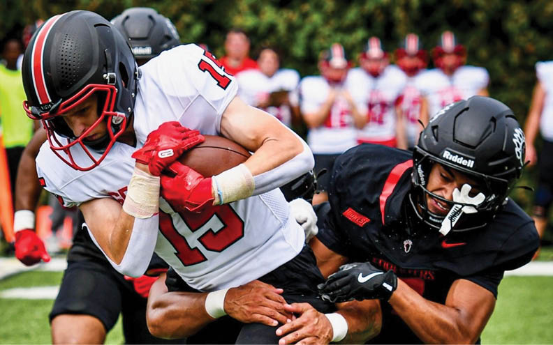 Two football players on a field. Description generated by AI