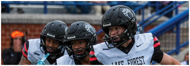 A group of football players on a field. Description generated by AI
