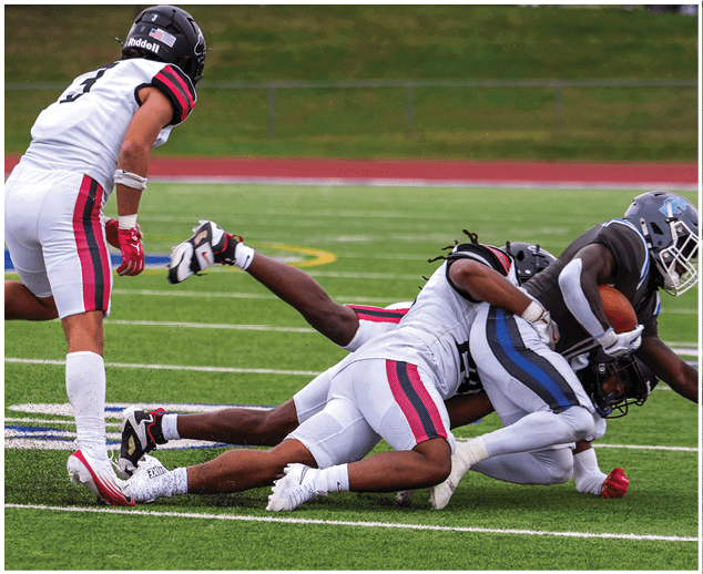 A group of football players on a field. Description generated by AI