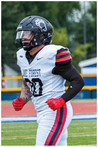 A football player wearing a helmet with the number 26 on it. Description generated by AI