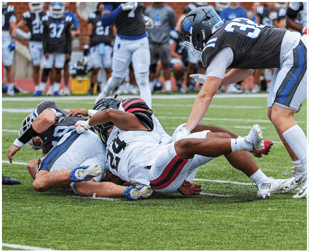 A group of football players on a field. Description generated by AI