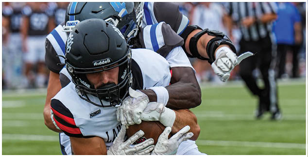 A group of football players wearing white and black uniforms. Description generated by AI
